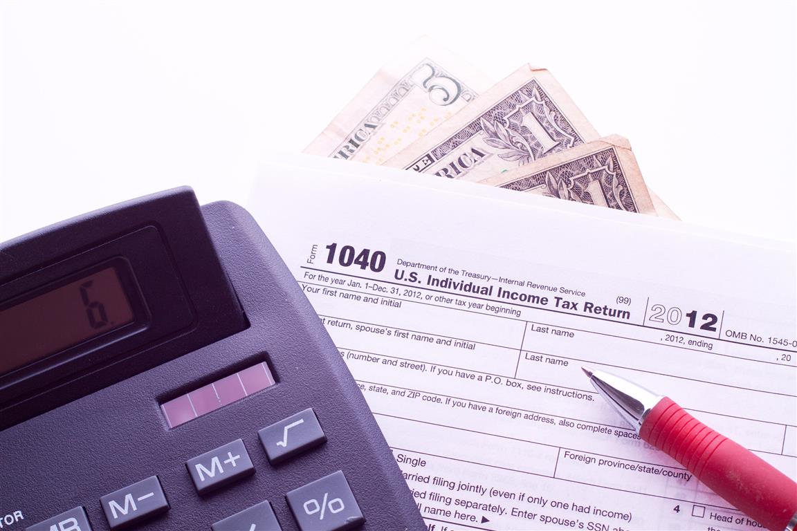 US tax form 1040 with calculator and pen - Credit stockvault