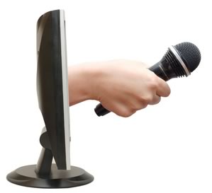 Hand with a microphone from the monitor © Vladimir Voronin - Fotolia
