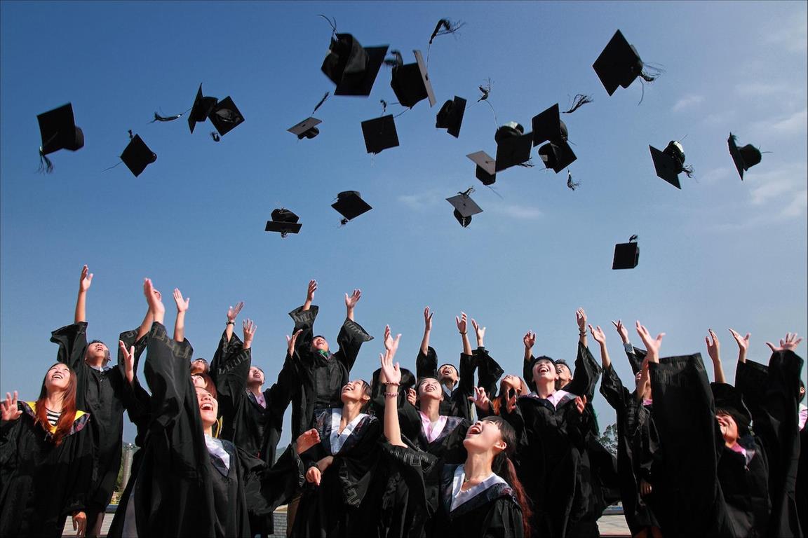 Les nouveaux diplômés portant des robes noires de l’Académie jettent des chapeaux en l’air - Credit: Pixabay