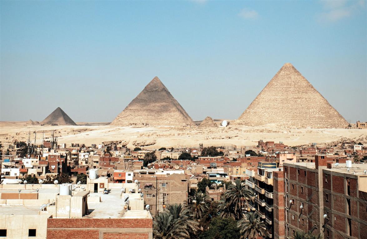 The famous pyramids in the middle of Giza downtown with houses in the morning - Credit: Photo by Flo P on Unsplash 